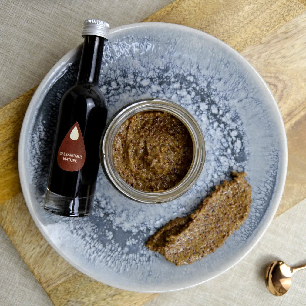 Moutarde au vinaigre balsamique dans un pot avec une bouteille de vinaigre